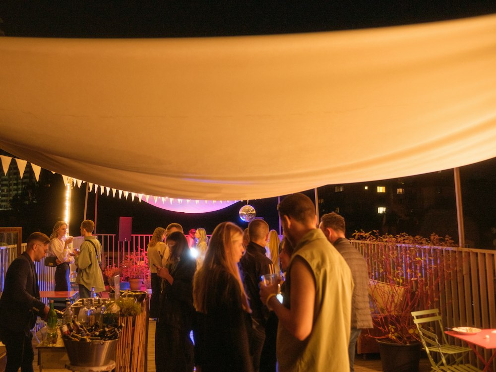 Convidados em um evento noturno sob tenda iluminada